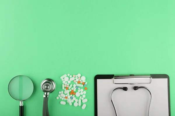 Medici sul posto di lavoro - tablet medico, stetoscopio, pillole e lente d'ingrandimento Fotografia Stock