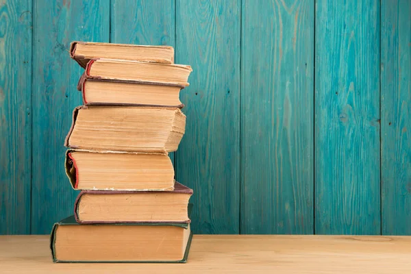 Bücherstapel auf dem Schreibtisch vor Holzgrund — Stockfoto