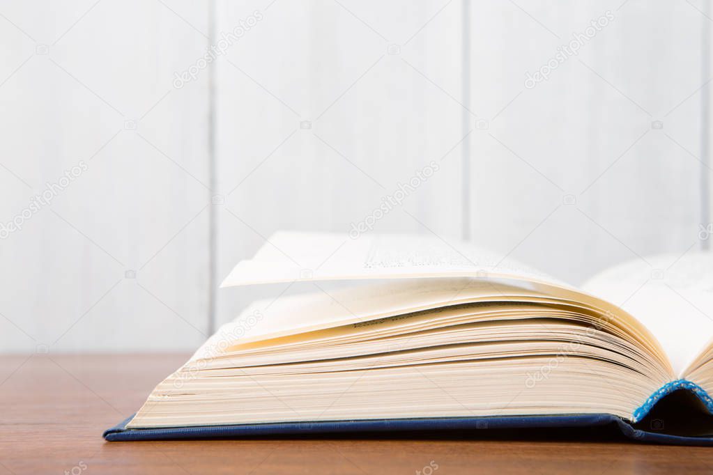 Open book on the desk over wooden background