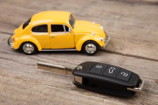 Toy car and key with remote alarm control on the wooden desk — Stock Photo, Image