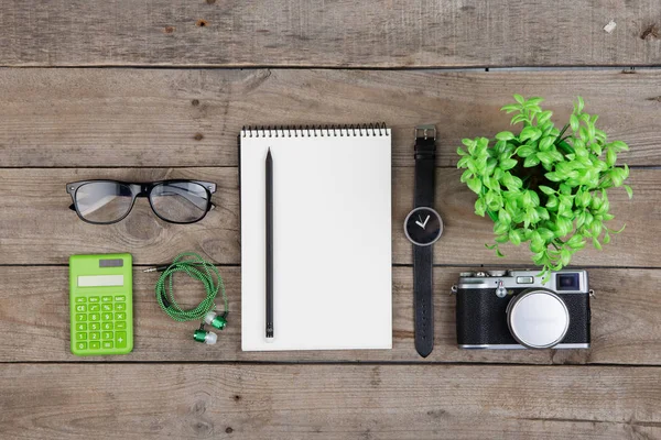 Jegyzetfüzet, szemüveg és kamera a fa asztalon — Stock Fotó