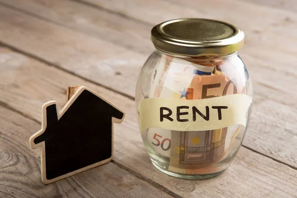 Conceito de financiamento imobiliário - vidro de dinheiro com palavra Rent — Fotografia de Stock