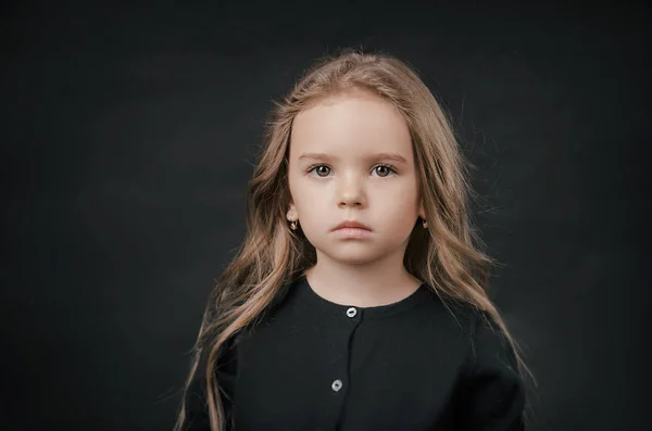Kleines Mädchen posiert perfekt im Studio auf schwarzem Hintergrund — Stockfoto