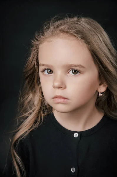 Little girl posing perfectly in the Studio on a black background — Stock Photo, Image