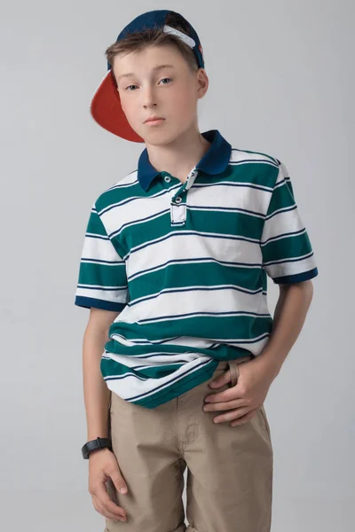 这个男孩在画室里摆着一顶时髦的棒球帽。 — 图库照片