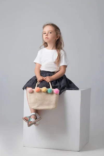 Chica con un bolso de mimbre posando en el estudio —  Fotos de Stock