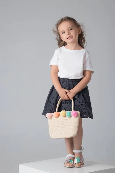 Chica con un bolso de mimbre posando en el estudio —  Fotos de Stock