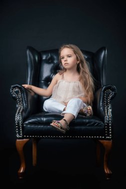 Bir siyah deri sandalye üzerinde poz kız