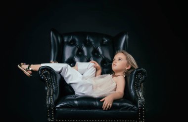 Bir siyah deri sandalye üzerinde poz kız