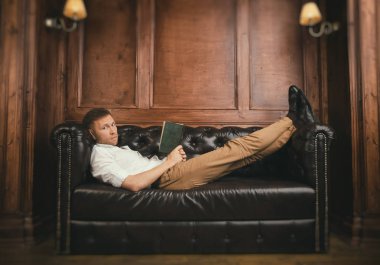 Adam kanepede bir kitapla