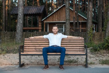 parkta bir bankta oturan genç adam