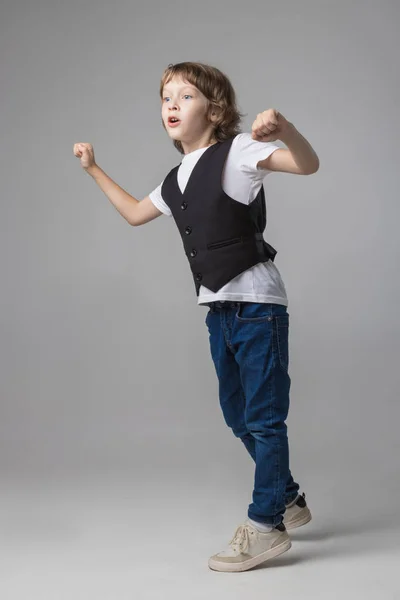 Niño posando emocionalmente en la cámara en el estudio sobre un fondo blanco — Foto de Stock