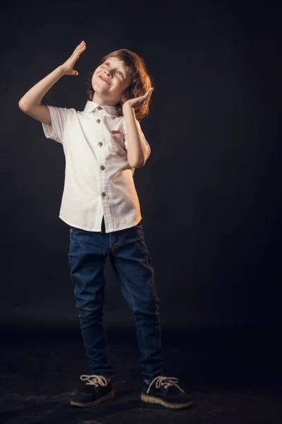 Bambino emotivamente posa sulla macchina fotografica in Studio su uno sfondo bianco — Foto Stock