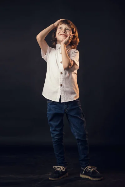 Bambino emotivamente posa sulla macchina fotografica in Studio su uno sfondo bianco — Foto Stock