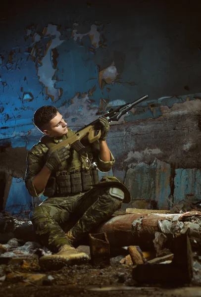 Die Menschen in Uniform mit Waffen in den Ruinen — Stockfoto