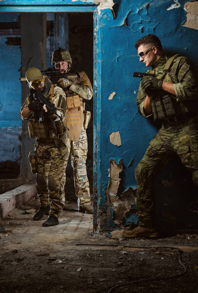 people in uniform with weapons in the ruins