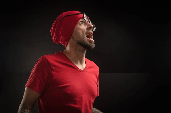 guy in a red hat and t-shirt posing on a black background