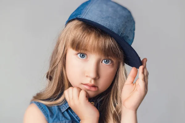 Das Kind im Studio posiert in modischer Kleidung in roter Farbe Herz — Stockfoto