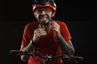 adam gözlük siyah bir arka plan üzerinde poz için bisiklet ve kask