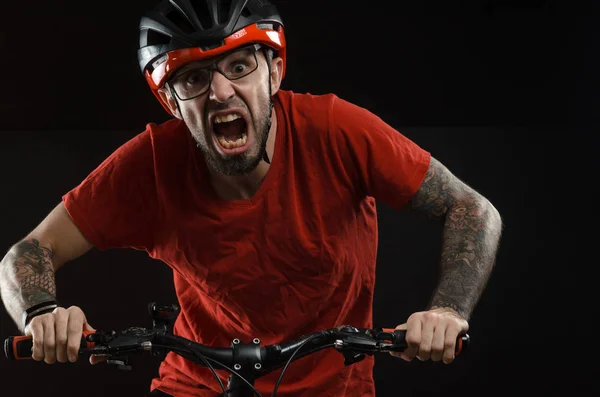 Chico en el casco y gafas en la bicicleta a posar sobre un fondo negro — Foto de Stock