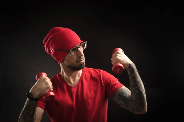 Tipo con un sombrero rojo y camiseta posando sobre un fondo negro — Foto de Stock