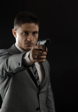 özel bir ajan poz bir silah ile bir takım elbise ceketli adamı