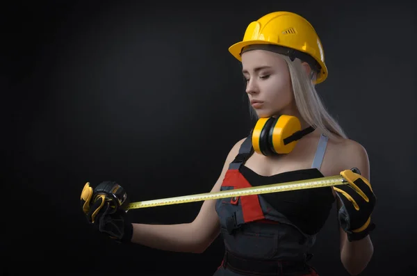 the girl in a construction firm works with a tape measure