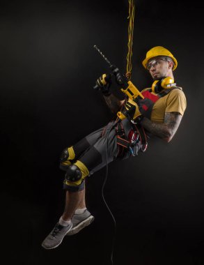 şık dağcı Builder elleri ve araçla birlikte çalışır. siyah arka plan. geçmiş Kopyala