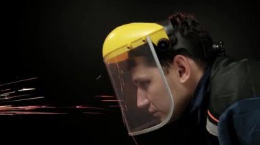 Bir açı değirmeni atma kullanarak bir inşaat işçisi kıvılcım. İş emniyet konsepti göz koruması ile.