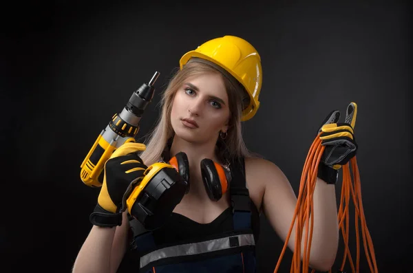 Meisje in bouw kleding en beschermende uitrusting poseren met een schroevendraaier — Stockfoto