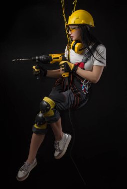 özel giysiler ve bir çalışma aracı siyah bir zemin üzerine poz kask bir işçi esmer kız