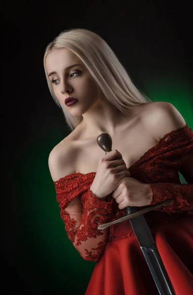 Menina bonita em vestido vermelho com espada — Fotografia de Stock