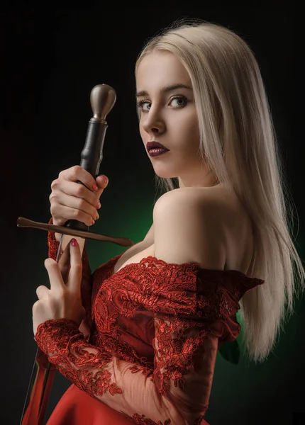 Menina bonita em vestido vermelho com espada — Fotografia de Stock