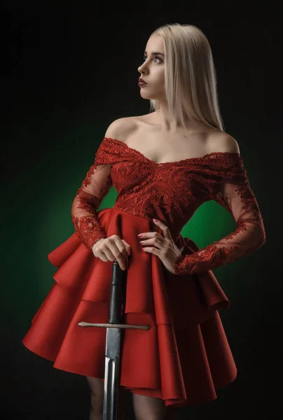 Menina bonita em vestido vermelho com espada — Fotografia de Stock