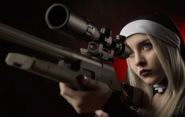 Девушка на черном фоне в монашеском платье позирует с пистолетом, прицеливается, стреляет — стоковое фото