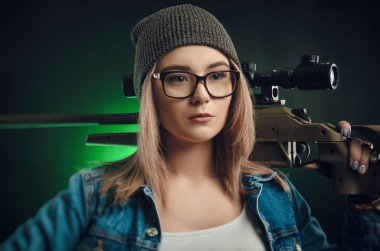 Kız silahla bir siyah arka plan keskin nişancı kapsamında poz