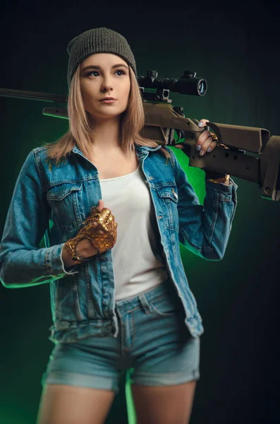 Menina com uma arma posando em um fundo preto sniper escopo — Fotografia de Stock