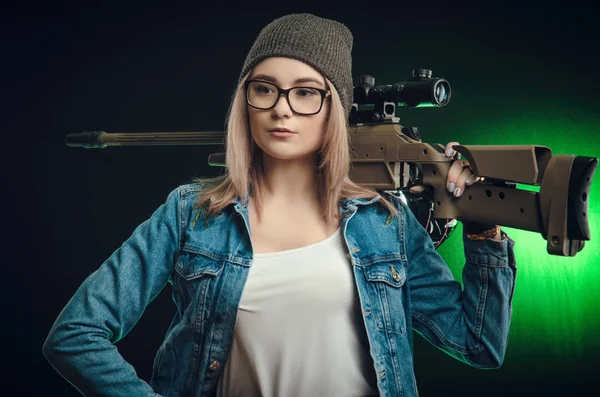 Chica con un arma posando sobre un francotirador de fondo negro — Foto de Stock