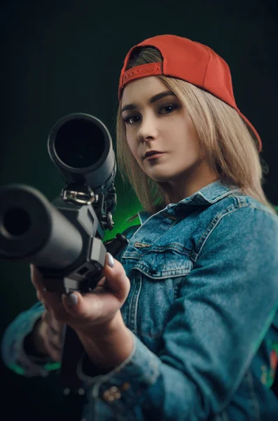 Chica con un arma posando sobre un francotirador de fondo negro — Foto de Stock