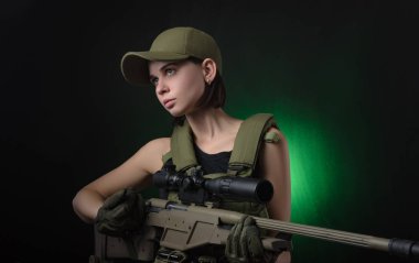 sevdanın karanlık bir arka plan üzerinde elinde bir silahla poz askeri özel giysili kızı