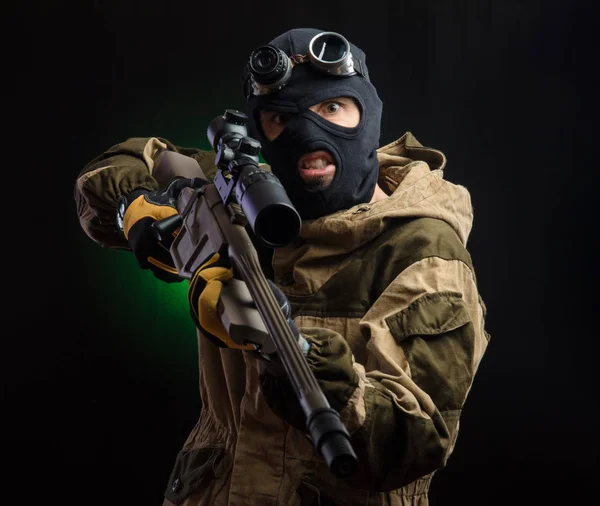 Der Typ in Schutzkleidung und schwarzer Maske mit Scharfschützengewehr — Stockfoto