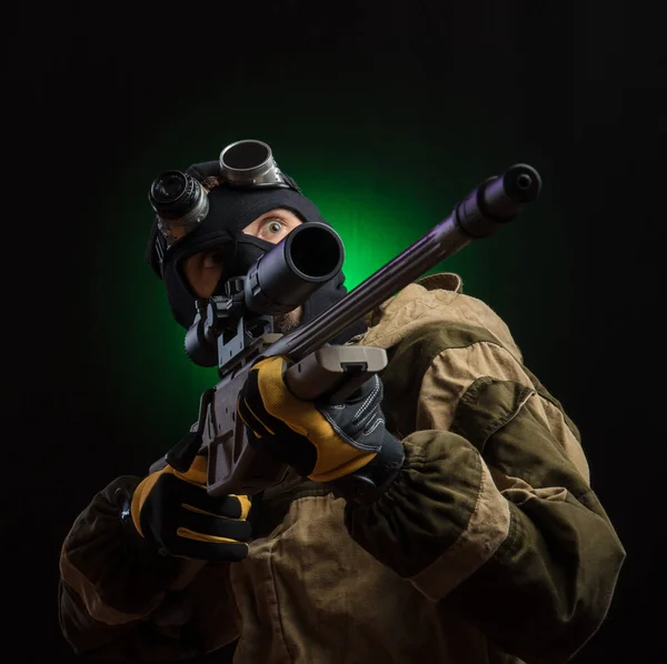 De man in een zwart masker met een sniper rifle en beschermende kleding — Stockfoto