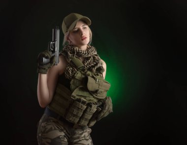 sevdanın karanlık bir arka plan üzerinde elinde bir silahla poz askeri özel giysili kızı