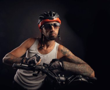 bir Bisiklet kask adam duygusal siyah bir arka plan üzerinde poz