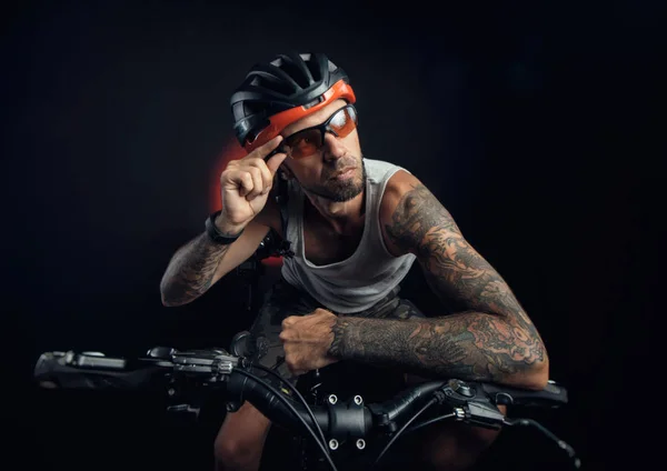 Chico en un casco de bicicleta emocionalmente posando sobre un fondo negro — Foto de Stock