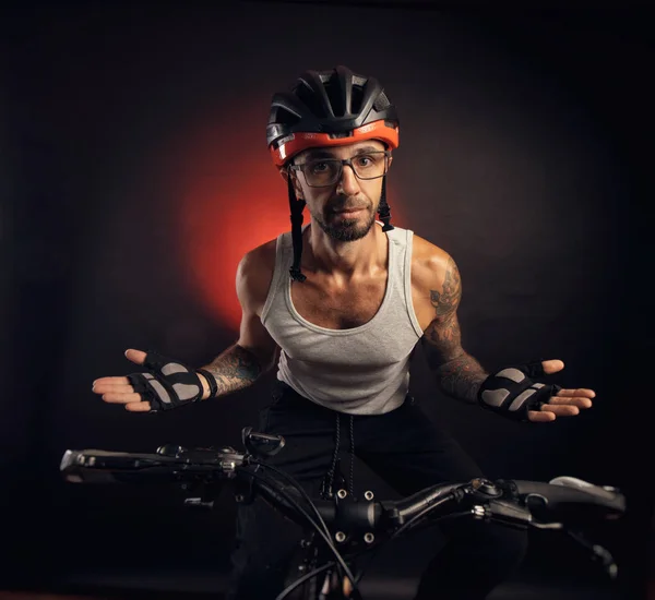 Chico en un casco de bicicleta emocionalmente posando sobre un fondo negro — Foto de Stock