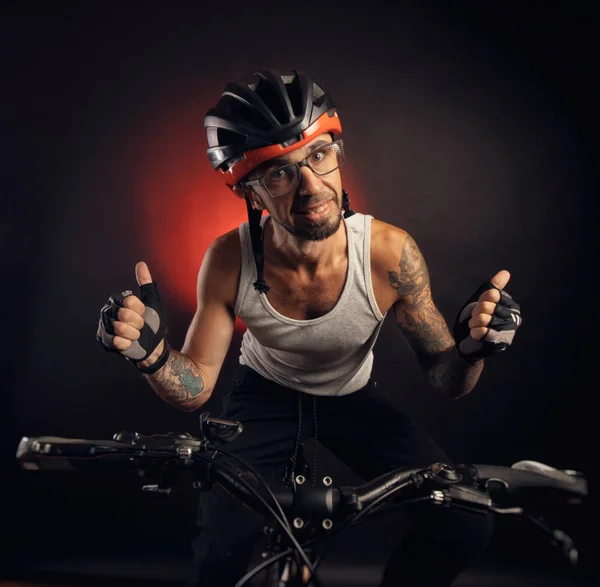 Guy in a Bicycle helmet emotionally posing on a black background — Stock Photo, Image