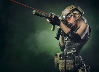 askeri tulum airsoft kız pus karanlık bir arka plan üzerinde elinde bir silah ile poz