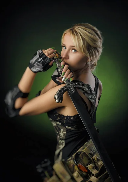 Het meisje in militaire speciale kleren poseren met een pistool in zijn handen op een donkere achtergrond in de nevel — Stockfoto