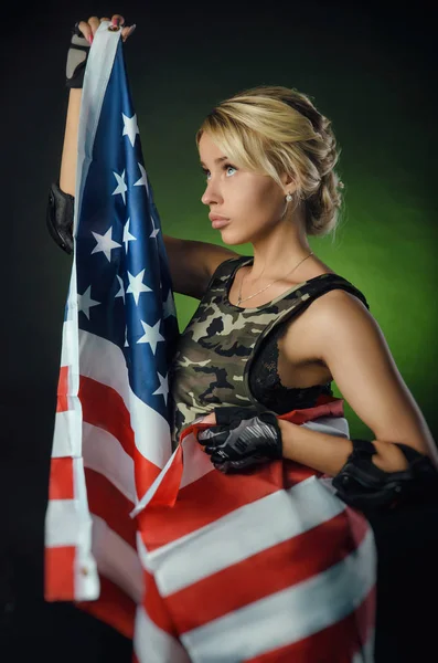 Flickan i militära overaller Airsoft poserar med en pistol i händerna på en mörk bakgrund i diset — Stockfoto
